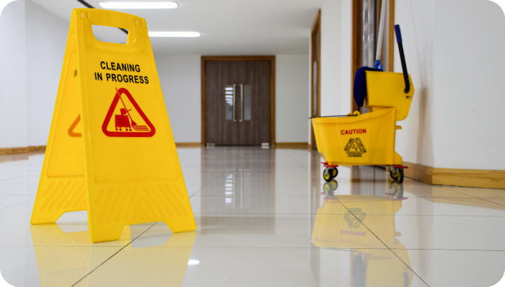 A yellow sign and bucket on the floor of a room.